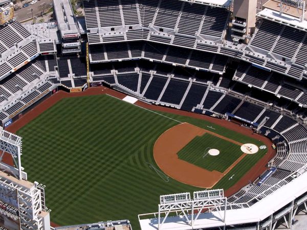 Aerial view of a packed baseball stadium with a green field and red-brown infield surrounded by stands.
