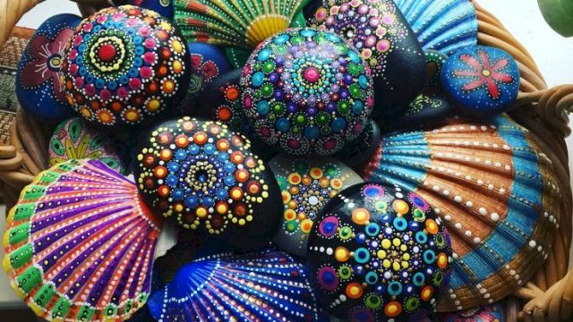 Colorfully painted decorative shells in a wicker basket near a window.